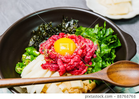 Korean food yukhoe bibimbap dish in black bowl 88768768