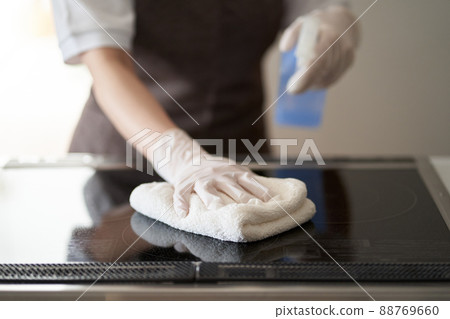 Asian woman cleaning an IH cooking heater 88769660