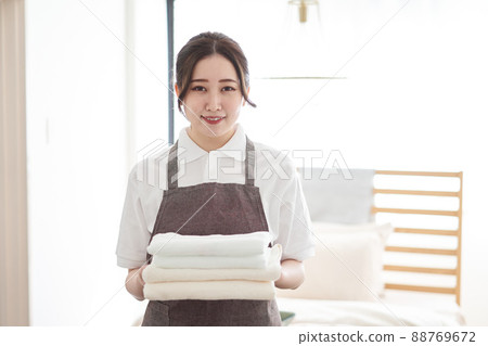 Asian woman folding towels and putting them away 88769672