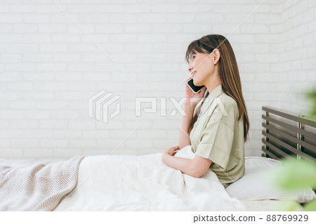 Middle-aged women who use smartphones in bed (calls / smiles) Middle-aged women who use smartphones in bed (calls / smiles) 88769929