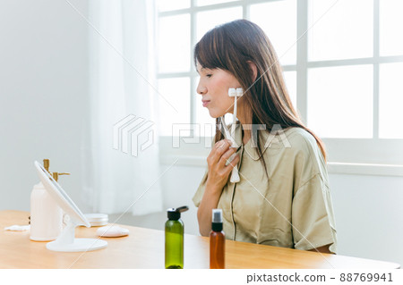 護理皮膚的中老年女性(面部滾輪、微笑) 護理皮膚的中老年女性(面部滾輪、微笑) 88769941