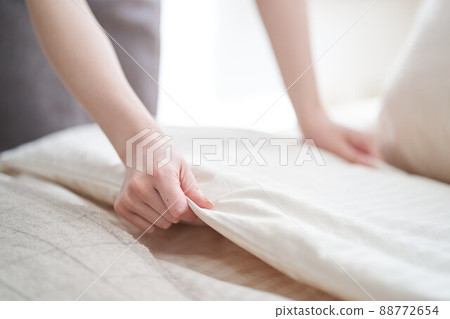 亞洲女人在臥室裡鋪床 88772654