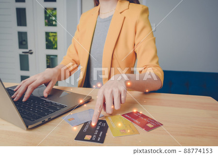 Business woman are choosing the best credit card. young girl shopping online, ordering, paying with many credit card, using laptop, makes secure payment online. internet bank service concept. 88774153