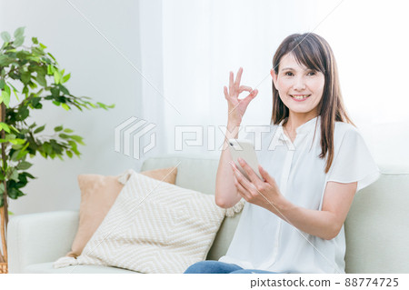 Middle-aged woman sitting on the sofa (see) Middle-aged woman sitting on the sofa (see) 88774725
