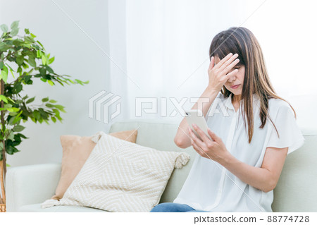 Middle-aged woman sitting on the sofa (depressed) 88774728