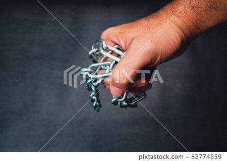 The mechanic carries a metal chain in his hand with a black color background 88774859