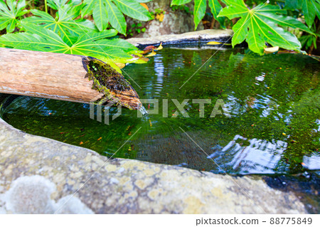 Shishi-odoshi with flowing water and ripples on the surface of the water 88775849