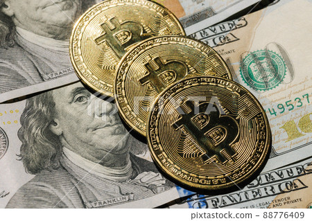 Close-up pf bitcoin on banknotes of one hundred dollars. Exchange US dollars for bitcoin. Cryptocurrency on dollar bills. Digital modern method of payment. Concep of virtual money. Close-up pf bitcoin on banknotes of one hundred dollars. Exchange US dollars for bitcoin. Cryptocurrency on dollar bills. Digital modern method of payment. Concep of virtual money. 88776409