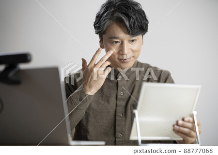 Image of middle-aged men's men's makeup applying BB cream to the mirror 88777068