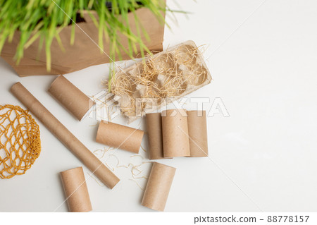 Household waste of cardboard and paper rollers lie on a white table 88778157