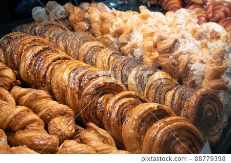 A variety of baked goods are on display. Showcase in the bakery. Various buns and pies A variety of baked goods are on display. Showcase in the bakery. Various buns and pies 88779398