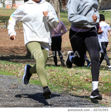 Two girls running fast uphill on a gravel path Two girls running fast uphill on a gravel path 88781993