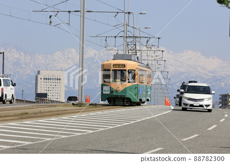 A retro tram that runs against the backdrop of the magnificent Tateyama mountain range A retro tram that runs against the backdrop of the magnificent Tateyama mountain range 88782300