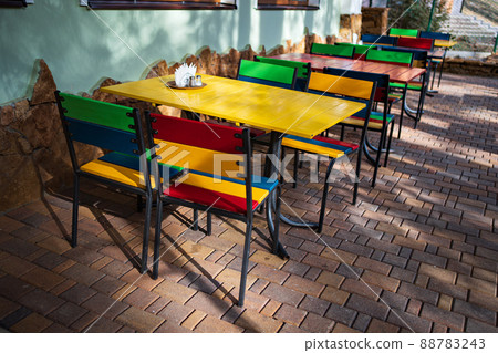 colorful wooden tables and chairs in a cafe on the street terrace in the park. 88783243