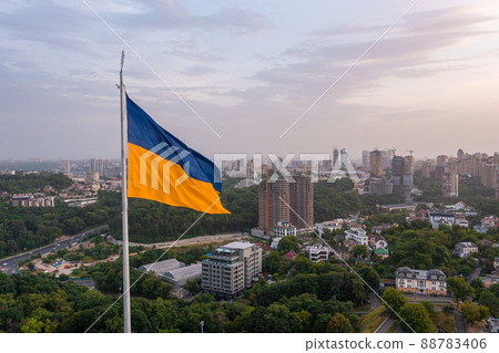 Aerial view of the Ukrainian flag waving in the wind against the city of Kyiv Aerial view of the Ukrainian flag waving in the wind against the city of Kyiv 88783406
