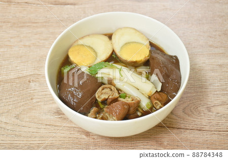 Chinese rice flour paste with pork and entrails topping egg yolk in soup on bowl Chinese rice flour paste with pork and entrails topping egg yolk in soup on bowl 88784348
