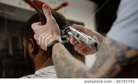 The trimmer cuts the curled hair of an African American - macro shot 88785743