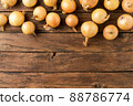 Overhead shot of fresh onions on rustic wooden table with copyspace 88786774