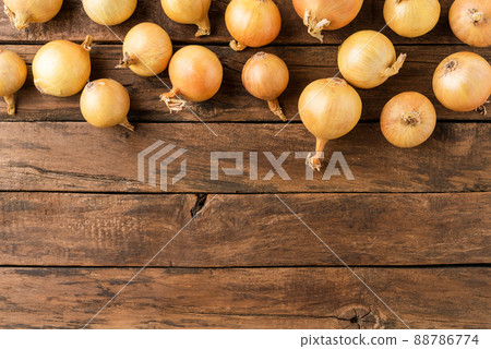 Overhead shot of fresh onions on rustic wooden table with copyspace 88786774