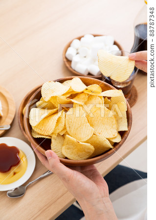 Middle woman eating potato chips 88787348