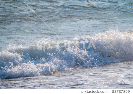 Splashes of water and foam against the sea on a sunny summer day Splashes of water and foam against the sea on a sunny summer day 88787809
