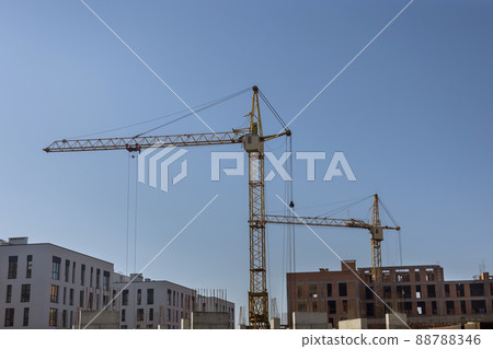Two tower cranes near building with concrete building under construction Two tower cranes near building with concrete building under construction 88788346