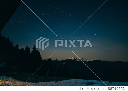 Snowy meadow, snowy mountains and stars in the background 88790352