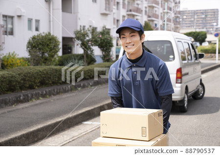 A courier man carrying luggage on a dolly 88790537