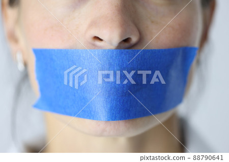Woman mouth is sealed with blue tape closeup 88790641