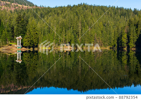 landscape with mountain lake in summer. forest reflection in the water. scenic travel background of synevyr, ukraine. beautiful nature scenery. green outdoor environment landscape with mountain lake in summer. forest reflection in the water. scenic travel background of synevyr, ukraine. beautiful nature scenery. green outdoor environment 88792354