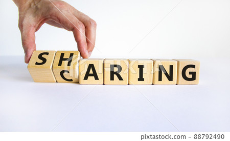 Sharing is caring symbol. Businessman turns wooden cubes and changes the word 'sharing' to 'caring'. Beautiful white table, white background. Business, sharing is caring concept. Copy space. 88792490