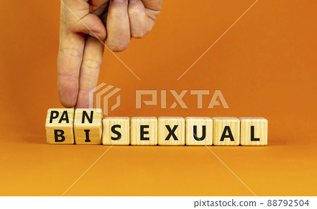 Pansexual or bisexual symbol. Doctor turns wooden cubes and changes the word 'bisexual' to 'pansexual'. Beautiful orange background, copy space. Social, pansexual or bisexual concept. Pansexual or bisexual symbol. Doctor turns wooden cubes and changes the word 'bisexual' to 'pansexual'. Beautiful orange background, copy space. Social, pansexual or bisexual concept. 88792504