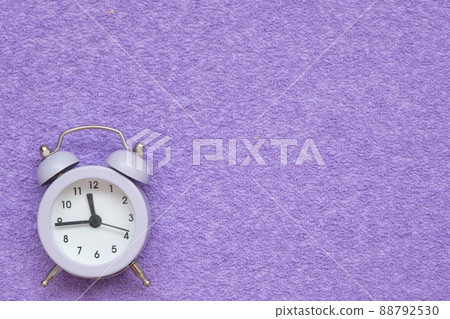 Alarm clock on a lilac suede background. There is space for text. Concept Alarm clock on a lilac suede background. There is space for text. Concept 88792530