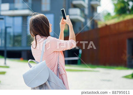 Professional business woman architect takes photo on smartphone in new project area. Construction of new residential complex 88795011