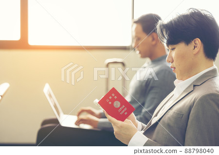 At the airport, a businessperson passes the time. waiting for the plane to take off 88798040