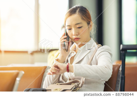 At the airport, a businessperson passes the time. waiting for the plane to take off 88798044