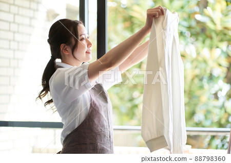 亞洲女人在窗邊晾衣服 亞洲女人在窗邊晾衣服 88798360