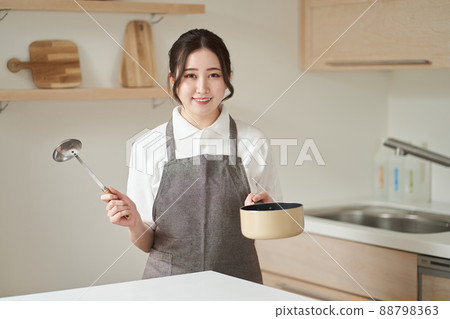 Asian woman cooking in the kitchen Asian woman cooking in the kitchen 88798363