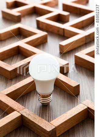 Light bulb in the maze game built by wood blocks, finding the right way to the success, idea concept Light bulb in the maze game built by wood blocks, finding the right way to the success, idea concept 88802237