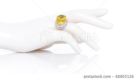 Lemon quartz with white topaz ring on plastic mannequin female hand. Collection of natural gemstones accessories. Studio shot Lemon quartz with white topaz ring on plastic mannequin female hand. Collection of natural gemstones accessories. Studio shot 88803126