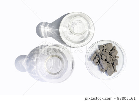 Aluminium powder in Chemical Watch Glass place next to Erlenmeyer flask and Flat Bottom Flask on white laboratory table. Top View Aluminium powder in Chemical Watch Glass place next to Erlenmeyer flask and Flat Bottom Flask on white laboratory table. Top View 88803161