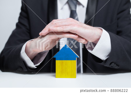 Protection, support and care of Ukraine concept. Ukrainian house and guarding male hands 88806222