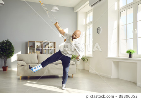 Funny positive man with numerous physical injuries having fun during rehabilitation at home. Funny positive man with numerous physical injuries having fun during rehabilitation at home. 88806352