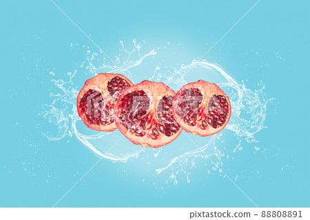 Pomegranate slices with water splash isolated on blue blackground. 88808891