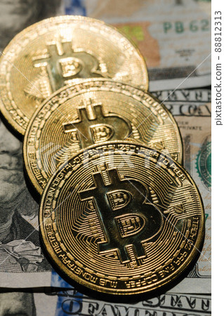 Close-up pf bitcoin on banknotes of one hundred dollars. Exchange US dollars for bitcoin. Cryptocurrency on dollar bills. Digital modern method of payment. Concep of virtual money. Close-up pf bitcoin on banknotes of one hundred dollars. Exchange US dollars for bitcoin. Cryptocurrency on dollar bills. Digital modern method of payment. Concep of virtual money. 88812313