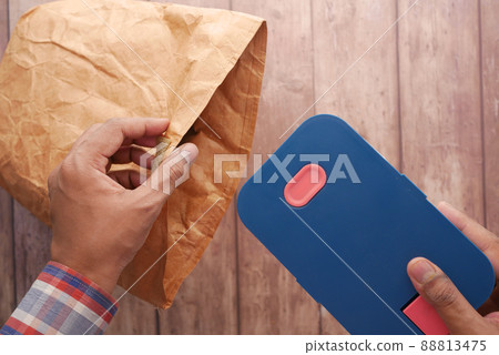 putting a lunch box in a lunch paper packet 88813475