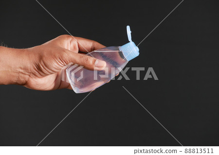 young man pouring hair oil on against black background young man pouring hair oil on against black background 88813511