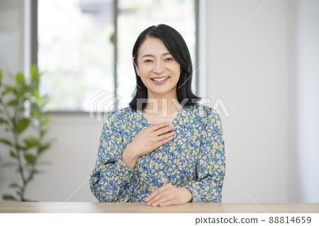 一個 40 多歲的微笑女人看著相機說話 88814659