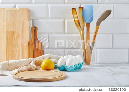 Kitchen countertop with cutting board, wooden spatulas and napkin 88820100