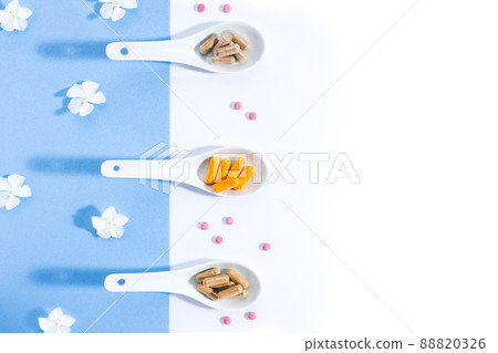 Flat lay composition of three white spoons with nutritional complexes on white and blue background with copy space. Foodstuffs concept. Flat lay composition of three white spoons with nutritional complexes on white and blue background with copy space. Foodstuffs concept. 88820326